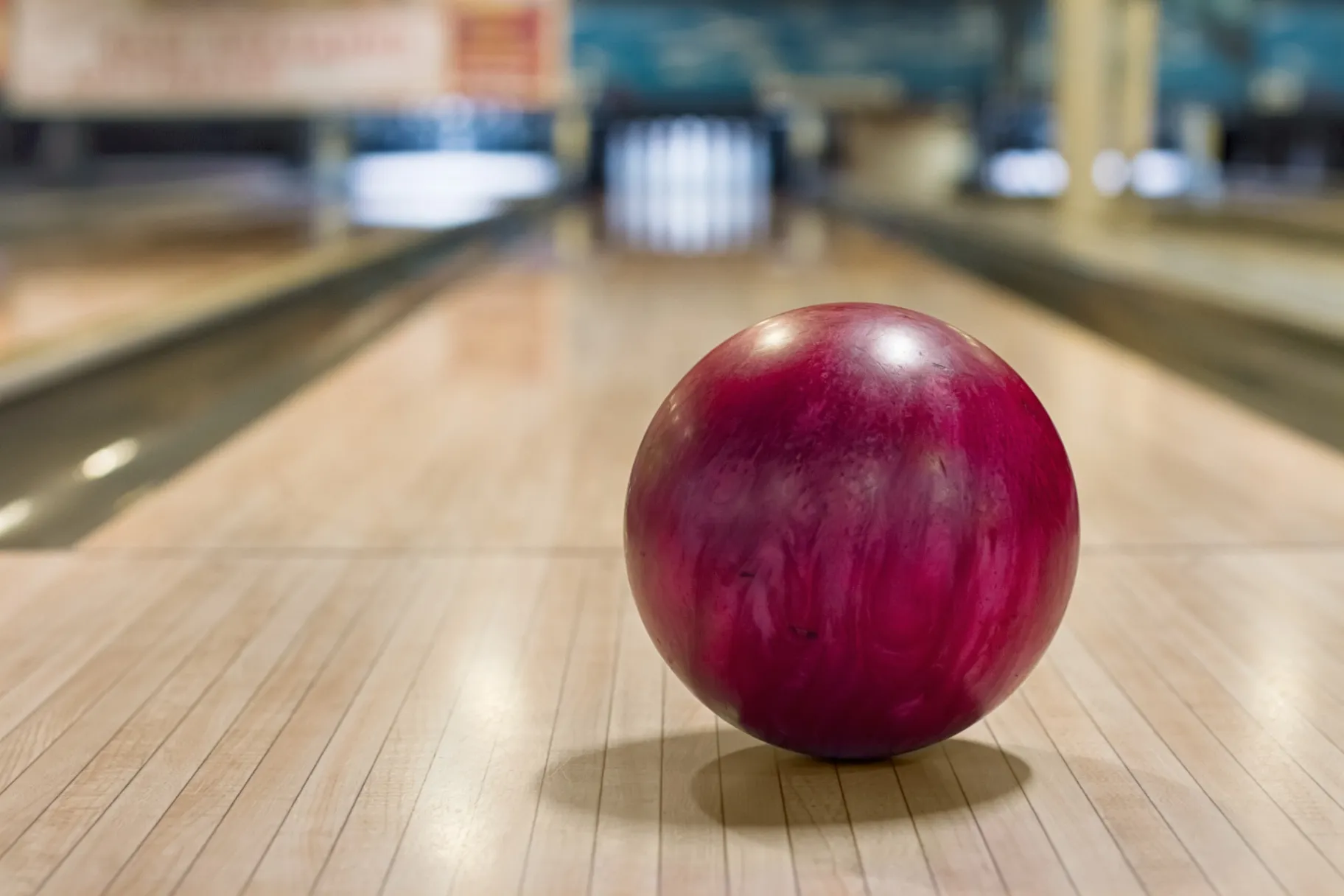 Red bowling ball on the track in the game center